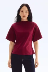 Remera color borgoña de corte holgado, con escote bote y mangas cortas.