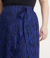 Pollera midi de crepé con estampa animal print cebra, elástico en la espalda, lazo lateral y volado en el bajo.