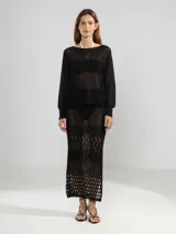 Sweater de escote bote, tejido en punto con lurex brillante. Presenta mangas largas con puños ajustados y un diseño de calce holgado.