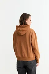 Canguro liso de color bordó, con capucha ajustable mediante cordones y bolsillo frontal tipo canguro.