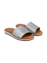 Sandalias tipo chinela con banda ancha superior de textura reptil en color plateado. Presenta una plantilla de color marrón y una suela de plataforma baja con borde blanco y base dentada en color marrón.
