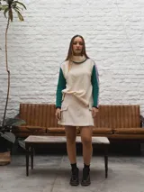 Buzo tejido de punto color crema con cuello alto y mangas largas con rayas horizontales en verde y lila.