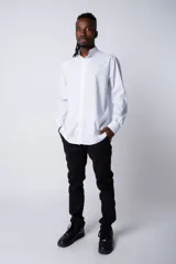 Camisa de manga larga en tela popelín color blanco, con cuello mao y cierre frontal de botones.