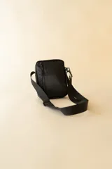 Bandolera negra con correa ajustable y logo de la marca Rusty en el frente.