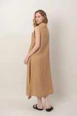 Vestido midi de lino color verde militar, sin mangas, con escote buche y bolsillos laterales, de corte relajado y fluido.