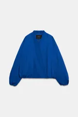 Chaqueta bomber de Zara Woman Collection color azul, con escote en pico, manga larga abullonada con puños elásticos, bolsillos delanteros y cierre frontal cruzado.