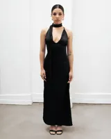 Vestido largo de seda color negro, con escote pronunciado tipo halter y detalle de lazo al cuello.