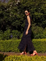 Vestido midi de punto sin mangas, con diseño de rombos en la parte superior y textura de red en la parte inferior. Confeccionado con hilo con lurex que aporta un brillo sutil, presenta un corte recto y tajos laterales en el ruedo.