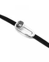 Pulsera Uno de 50 con cordones de cuero negro, pieza central bañada en plata con cristal facetado color gris y cierre de nudo corredizo con cuentas plateadas.
