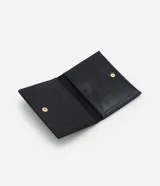 Billetera tipo sobre color negro de PU texturizado con efecto brillante y cierre de botón a presión con aplique metálico dorado.