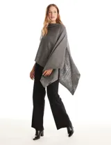 Poncho tejido de punto con diseño asimétrico y aberturas laterales para los brazos.