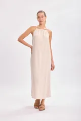 Vestido largo color beige, de corte recto y breteles finos.