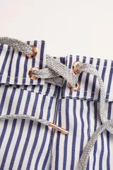 Short de baño con rayas verticales azules y blancas, pretina elastizada con cordón ajustable, bolsillos laterales y traseros con cierre.