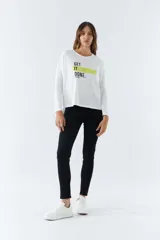 Remera de manga larga con escote redondo, confeccionada en algodón. Presenta un estampado frontal con la frase 'GET IT DONE' y una franja horizontal en color verde lima.