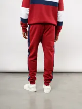 Pantalon de jogging azul de felpa, con franjas laterales en blanco y azul marino. Presenta el escudo del Club Nacional de Football en el muslo derecho y el logo de Umbro en el izquierdo.