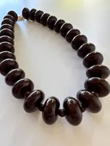 Collar de cuentas redondas y aplanadas con efecto marmolado en tonos grisáceos, con cierre metálico dorado.