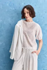 Blusa de manga corta color rosado con estampa orgánica de inspiración floral, cuello redondo y ajuste mediante lazo en el ruedo.
