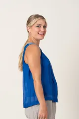 Blusa sin mangas de seda color azul con detalle de bordado plateado en los hombros.