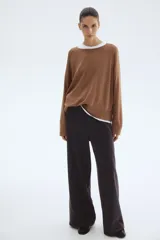 Pantalón de tejido de punto pesado color gris oscuro, tiro alto con elástico oculto en la cintura y piernas rectas con pliegues marcados.