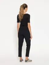 Babucha negra confeccionada en bisou, con cintura elastizada y jareta con lazo de cinta valenciana a tono. Cuenta con bolsillos laterales en el delantero y un calce cómodo.