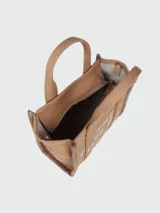 Bolso tipo tote de Marc Jacobs, confeccionado en tejido jacquard negro con detalles en color crema. Presenta el nombre del modelo estampado en el frente, doble asa superior y correa ajustable extraíble.