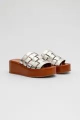 Sandalias de cuero Agnès Lenoble con plataforma plana y suela de madera, capellada con tiras doradas entrelazadas.