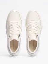 Zapatillas Tommy Hilfiger de corte bajo, color blanco con detalles en plateado en el talón. Confeccionadas en piel, con interior de poliéster y suela de goma. Presentan el logo de la marca en el lateral y en relieve en el talón.