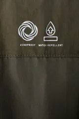 Campera parka acolchada repelente al agua y rompevientos, con cuello alto, capucha ajustable, cierre frontal con solapa y bolsillos frontales tipo parche y calientamanos.