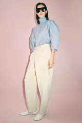 Pantalón de tiro medio confeccionado en algodón, con diseño cruzado en la cintura y cierre frontal con botones. Presenta trabillas para cinturón, bolsillos laterales ocultos y un bolsillo frontal con solapa y botón.