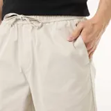 Bermuda chino color gris claro, de corte recto, con cintura elástica ajustable mediante cordón y bolsillos laterales.