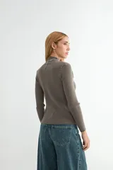 Polera de tejido de punto acanalado en color gris oscuro, con cuello alto y mangas largas ajustadas.