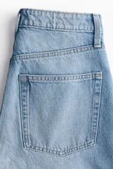 Jean de tiro alto con cinco bolsillos, confeccionado en denim de algodón rígido en color celeste claro, de piernas amplias y corte holgado con terminación recta.