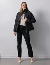 Campera beige capitoneada con capucha, cierre frontal y bolsillos laterales.