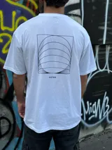 Remera blanca de algodón con corte oversize y estampado en la espalda con diseño geométrico en negro y la palabra 'OSTER' en la parte inferior.