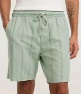 Bermuda recta de playa en color blanco roto, confeccionada en algodón texturizado con efecto de rayas verticales. Posee cintura elástica con cordón ajustable.