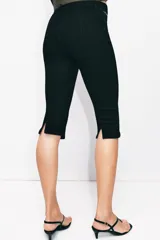 Jeans capri de tiro medio en color negro, con diseño de falsos bolsillos delanteros con cierre metálico y pierna corta.