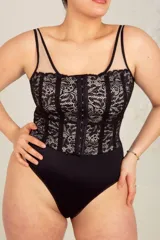 Body colaless negro con puntilla blanca y breteles regulables transparentes. Tiene ganchos reforzados en la parte delantera y broches en la entrepierna con fundillo de algodón.