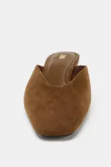 Zapato tipo mule destalonado de ante color marrón, con tacón bajo tipo cuña y punta cuadrada.