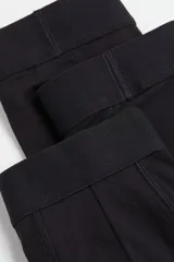 Pack de tres calzoncillos tipo trunk de color negro, confeccionados en punto elástico con costuras planas y cintura elástica. Presentan piernas cortas y parte delantera forrada para mayor comodidad.