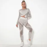 Conjunto deportivo gris con detalles en marrón, compuesto por un top de mangas largas y calzas de tiro alto.