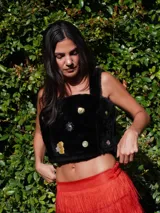 Top negro de corderito natural con breteles y broches en la espalda. Decorado con pins variados.