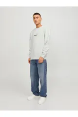 Buzo de cuello redondo y manga larga, confeccionado en tejido de bucle color gris melange. Presenta un corte relajado y un pequeño estampado tipográfico en el centro del pecho.