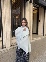 Poncho de hilo liviano en color verde claro, con diseño de cuello alto y caída fluida, ideal para media estación.