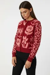 Cardigan de algodón con tejido jacquard, corte ajustado al cuerpo, cuello redondo y cierre frontal con botones. Presenta un diseño estampado con flores en el cuerpo y patrón de animal print en las mangas.