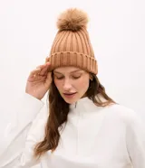 Gorro de punto acanalado color tostado, con diseño de doblez en el borde y pompón de pelo sintético en la parte superior.