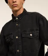 Camisa masculina Blue Steel de corte oversized tipo boxy, confeccionada en denim de algodón con efecto marmolado. Presenta cuello camisero, mangas largas, cierre frontal con botones metálicos y dos bolsillos con solapa en el pecho.