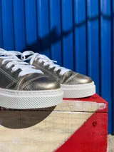 Championes de cuero color peltre con cordones blancos y suela blanca.