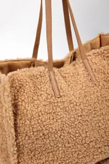 Cartera tipo tote bag de textura de corderito sintético en color rosado, con asas largas de cuero sintético en tono nude.