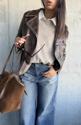 Chaqueta estilo biker de cuero vegano en color chocolate, con cierre frontal asimétrico, solapas clásicas y detalles de costuras visibles.