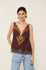 Top de viscosa color marrón, sin mangas, con tirantes ajustables, escote en V pronunciado, diseño transparente con detalles de encaje aplicado y terminaciones en ondas.